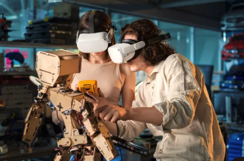 2 women using VR headsets to build a machine